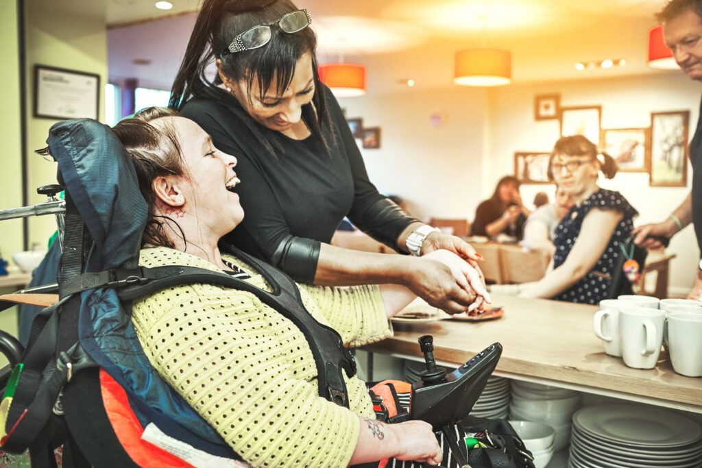 mhy care - Wheelchair down syndrome disability girl patient in clinic or hospital with nurse or professional healthcare worker. Nursing and medical caregiver helping happy, friendly and young disabled person